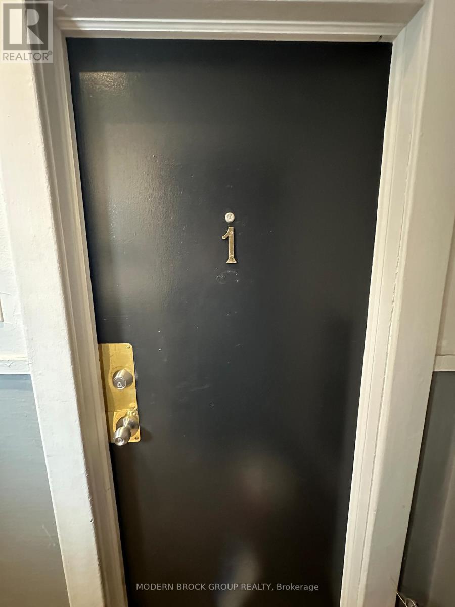 A black door with a gold handle and a number 1 on it.