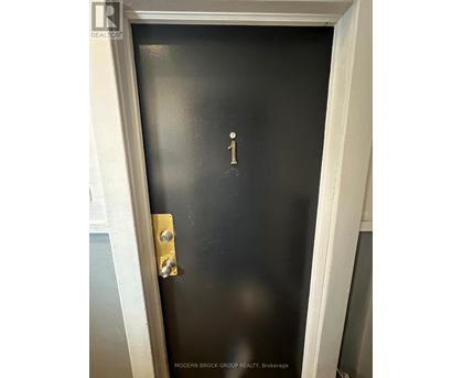 A black door with a gold handle and a number 1 on it.