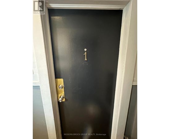 A black door with a gold handle and a number 1 on it.