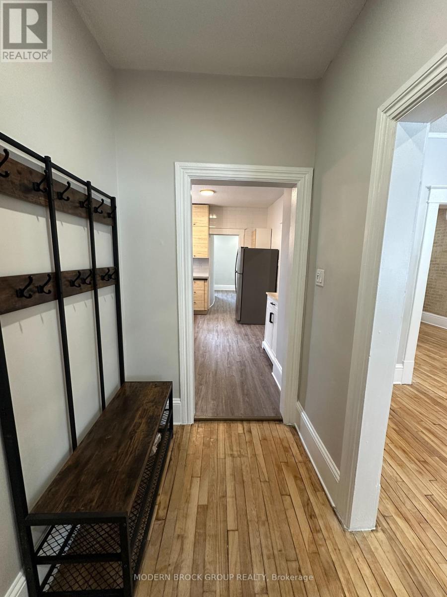 A hallway with a wooden floor and white walls.