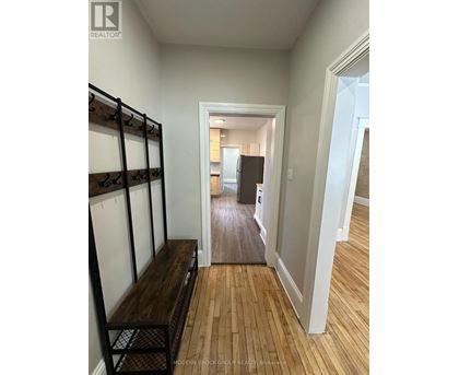 A hallway with a wooden floor and white walls.