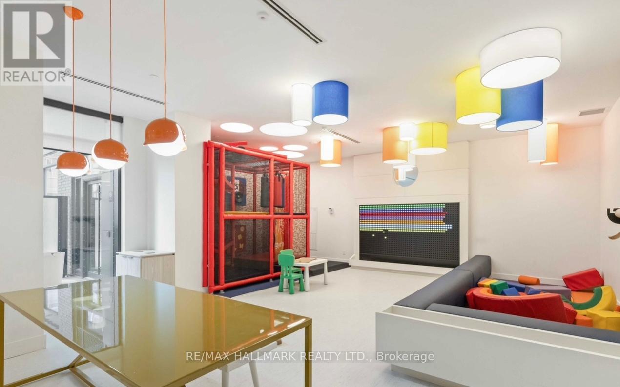 A modern living room with a glass table and colorful chairs.