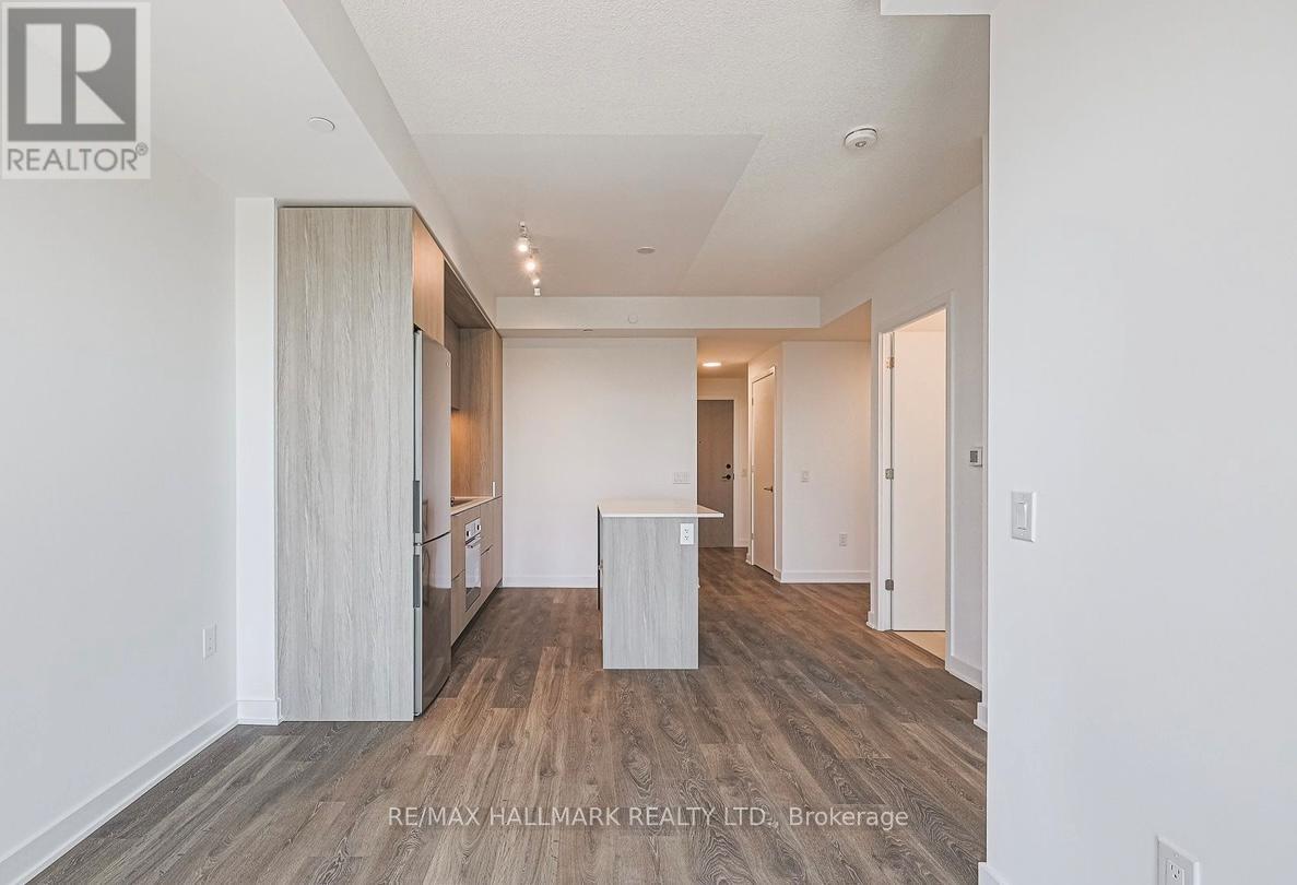 A spacious room with wooden flooring and white walls.
