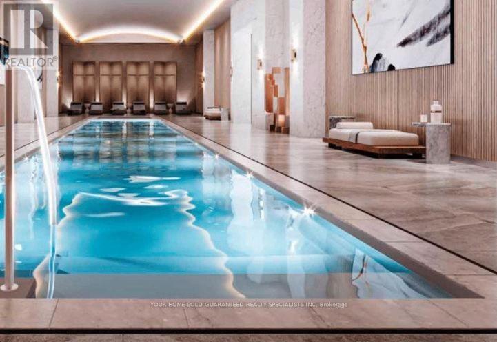 A large indoor swimming pool with a waterfall feature.