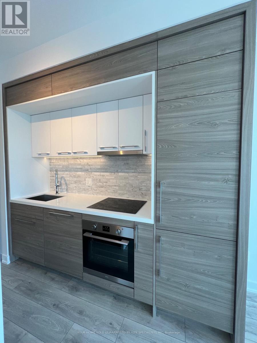 A modern kitchen with a stainless steel oven and wooden cabinets.