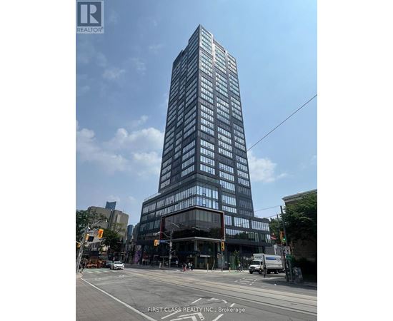 A tall building with many windows is the main focus of the image.