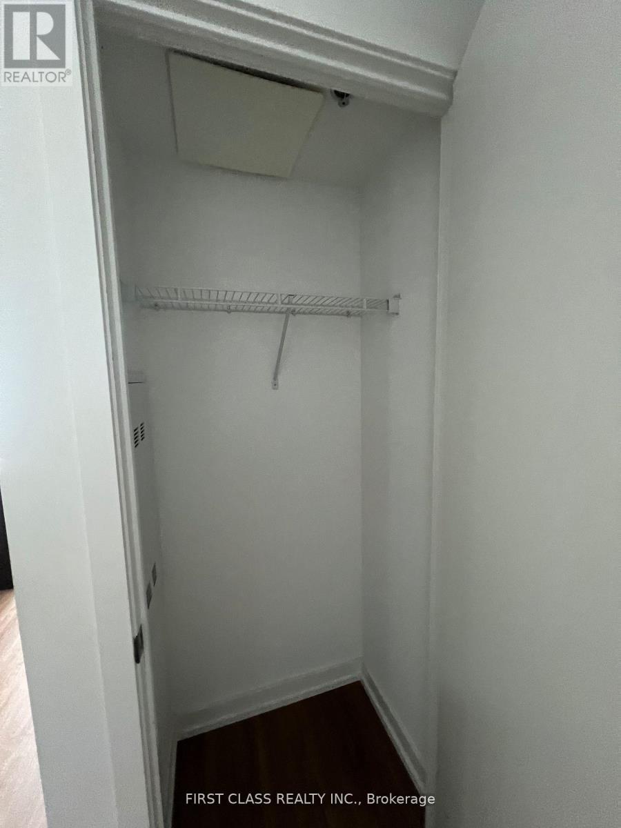 A white closet with a shelf and a hanger.