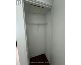 A white closet with a shelf and a hanger.
