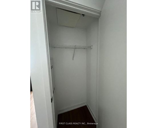 A white closet with a shelf and a hanger.
