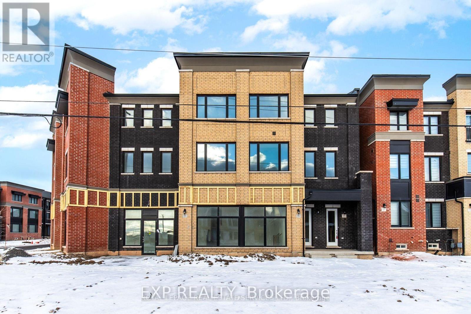 A row of modern townhouses with different colored brick exteriors.