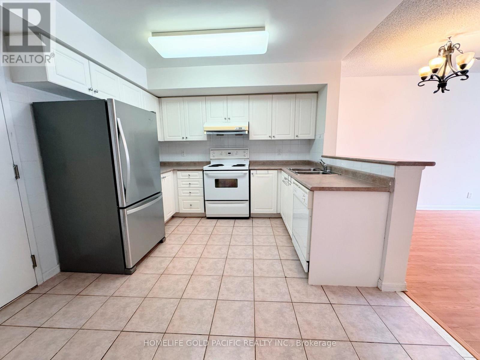 A kitchen with white cabinets and a black refrigerator.