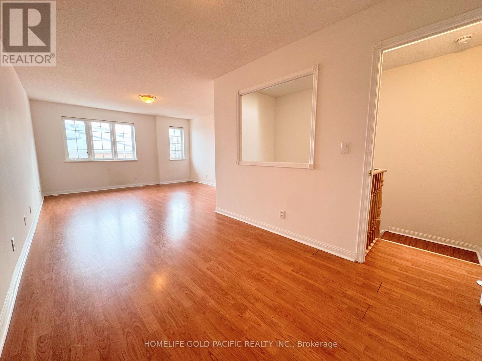 A room with wooden flooring and white walls.
