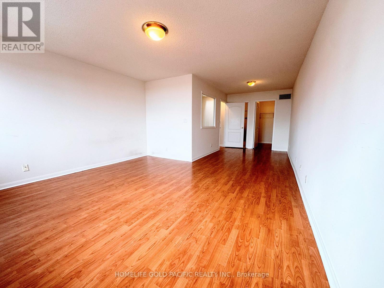 A room with wooden flooring and white walls.
