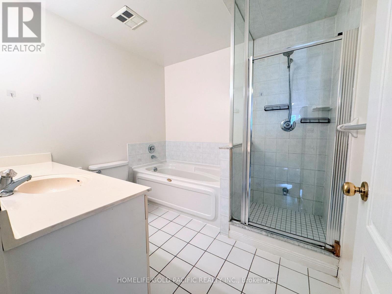 A white bathroom with a glass shower stall and a white bathtub.