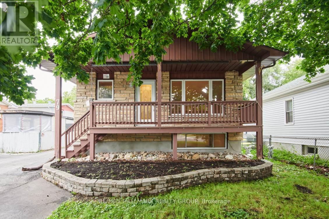 A house with a wooden deck and a landscaped front yard.