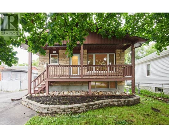 A house with a wooden deck and a landscaped front yard.