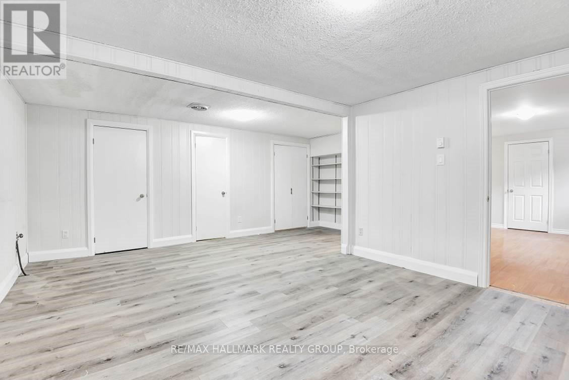 A spacious room with white walls and wooden flooring.