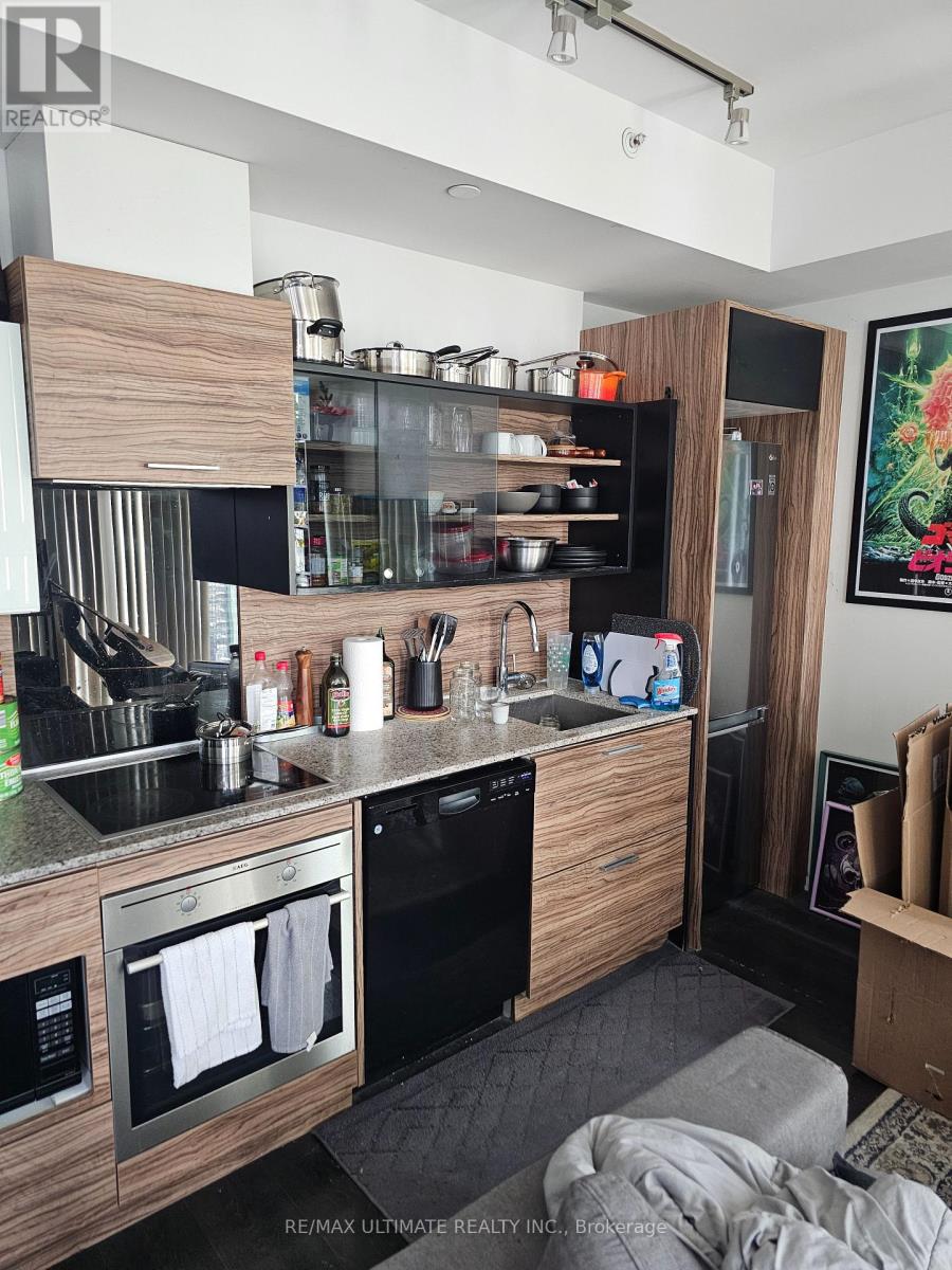 A modern kitchen with a black dishwasher and wooden cabinets.