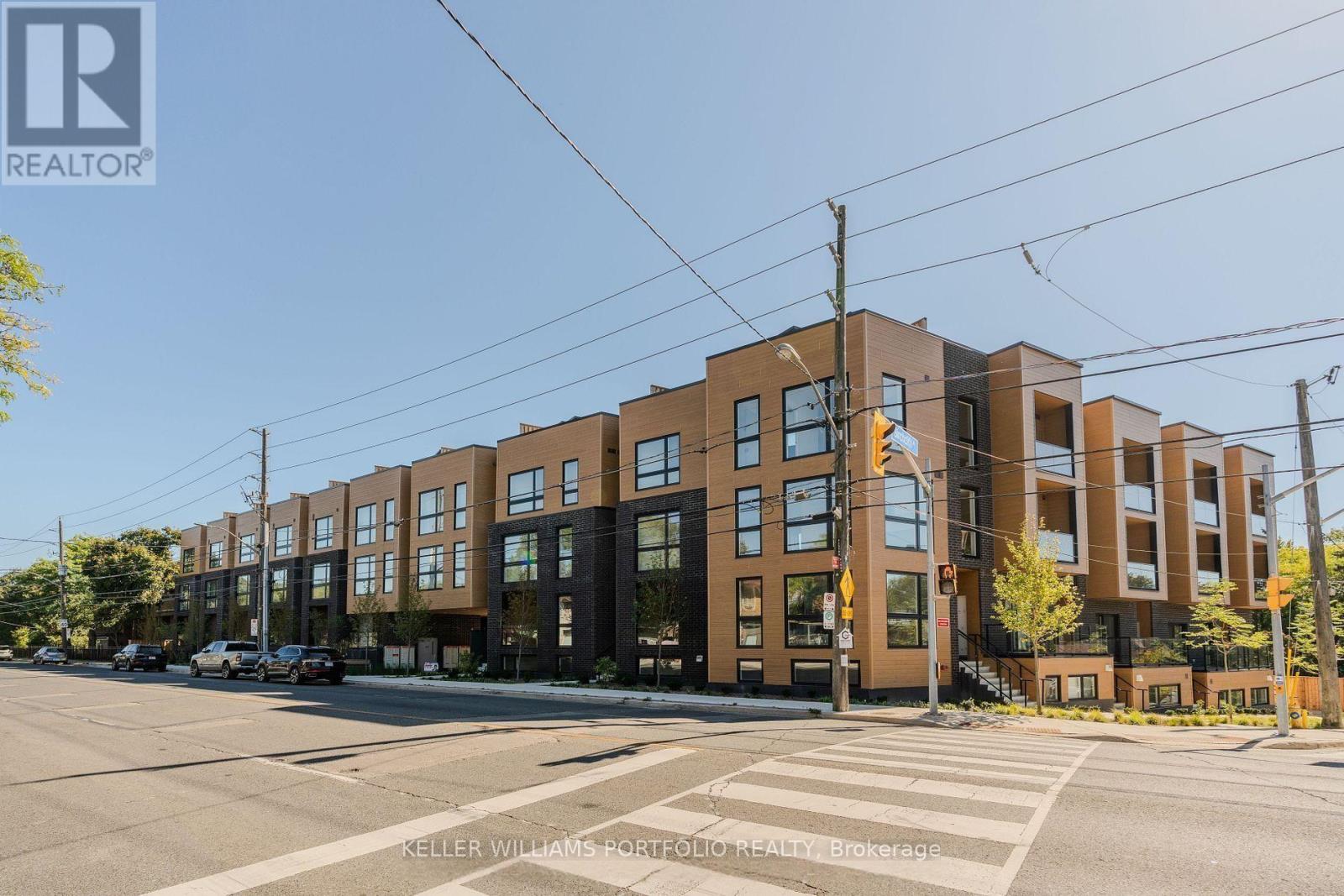 A street view of a residential area with apartment buildings and a crosswalk.