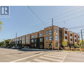 A street view of a residential area with apartment buildings and a crosswalk.