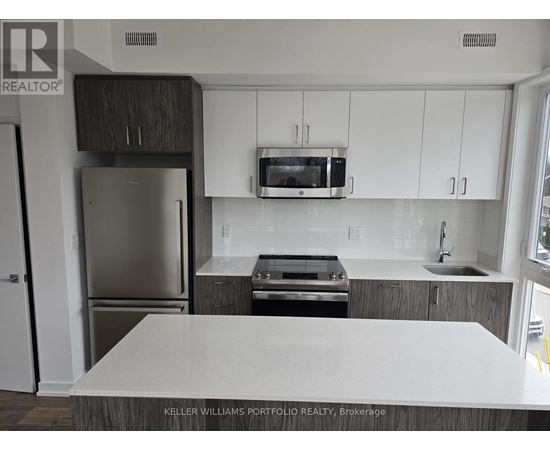 A kitchen with a white counter top and stainless steel appliances.