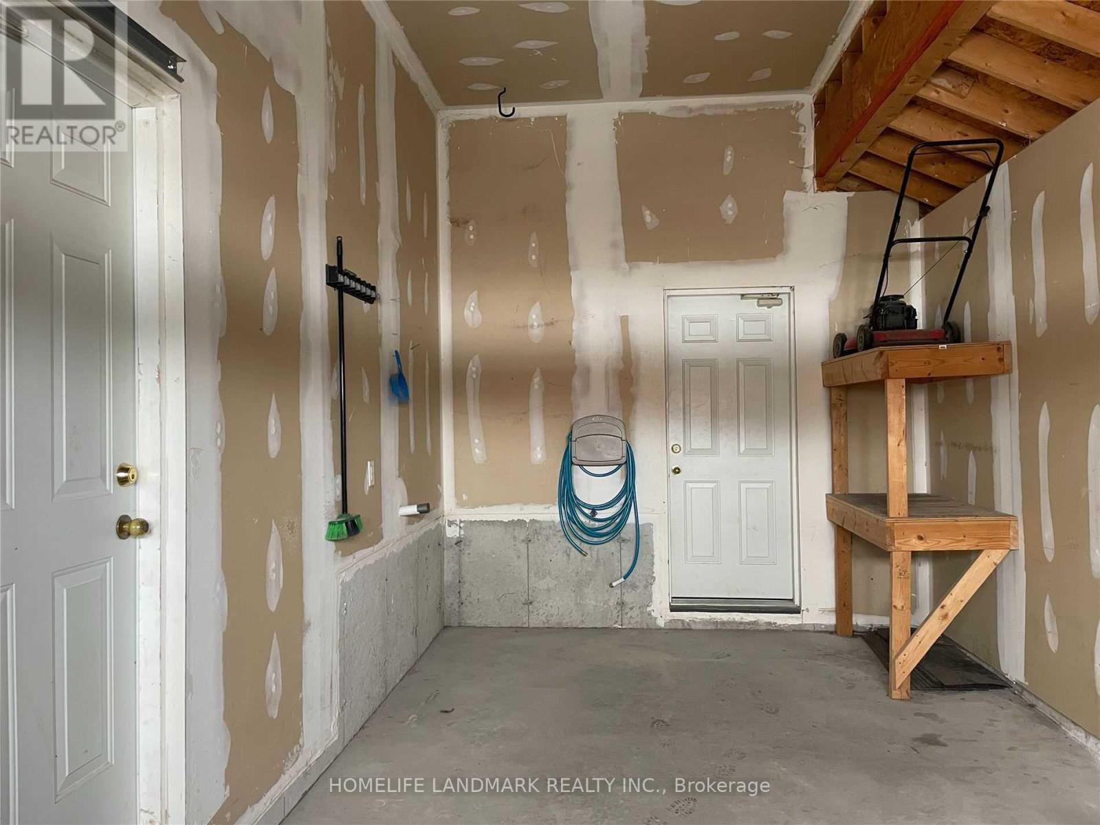 A room under construction with a white door and a wooden shelf.
