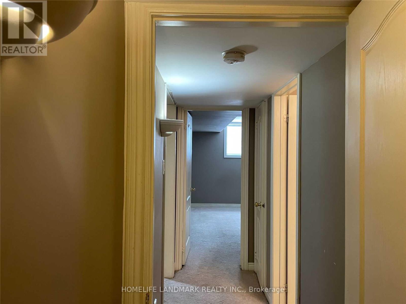 A hallway with a light on the ceiling and a door on the right.