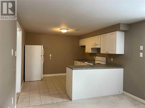 A kitchen with a white refrigerator and cabinets.
