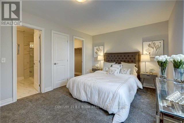 A bedroom with a bed, nightstands, and a vase of flowers.