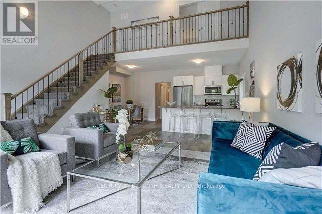 A living room with a glass coffee table and a staircase.