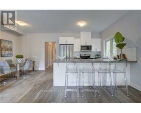 A modern kitchen with white cabinets and a bar area.