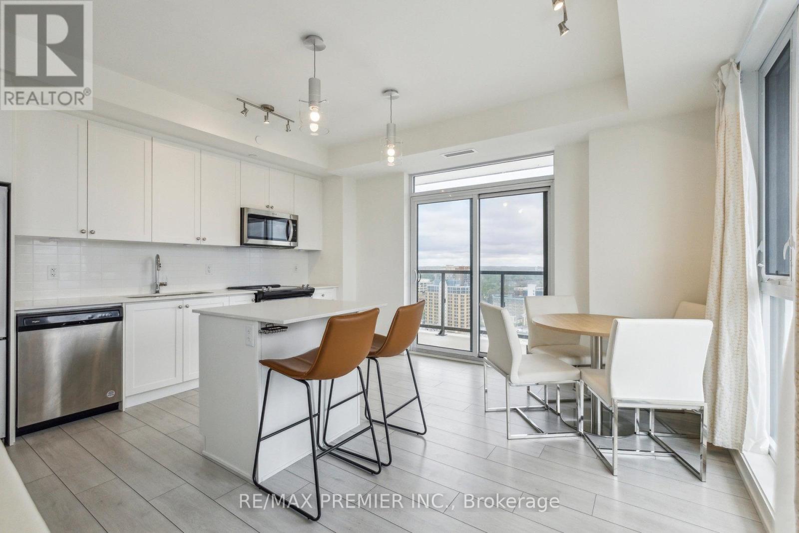 A kitchen with white cabinets and a stainless steel refrigerator.