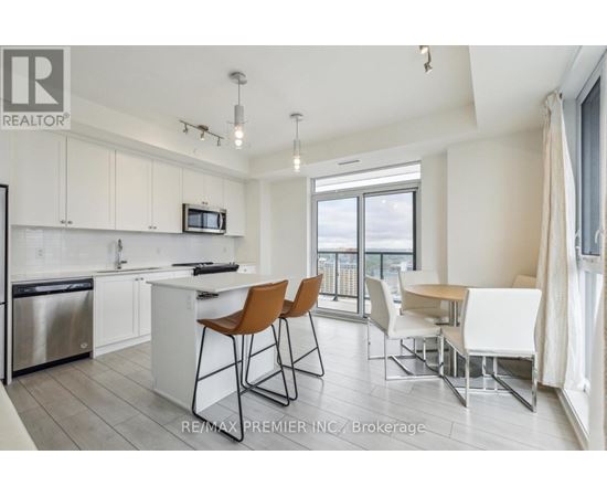 A kitchen with white cabinets and a stainless steel refrigerator.