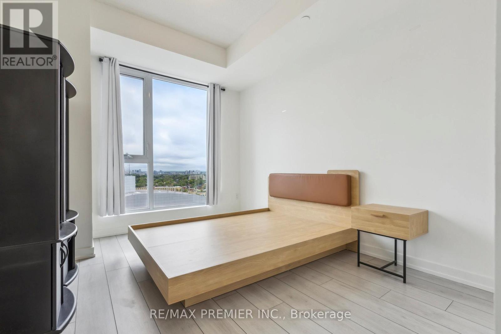 A bedroom with a large bed and a window overlooking the ocean.