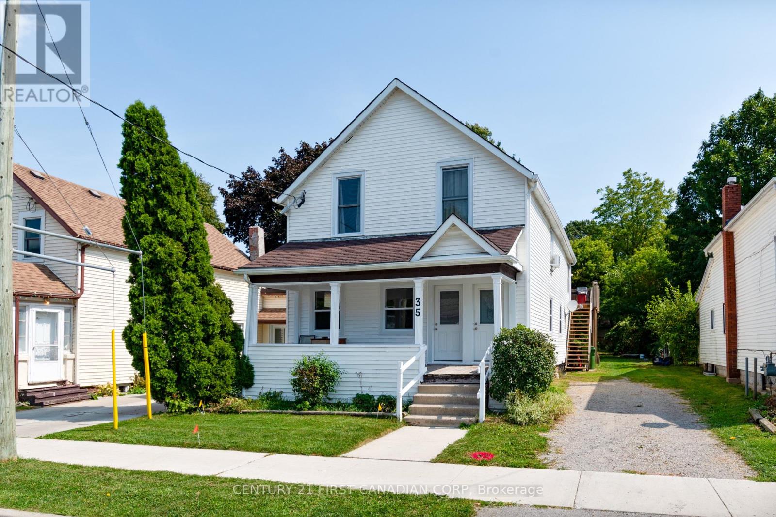 A white house with a brown roof and a small front porch.