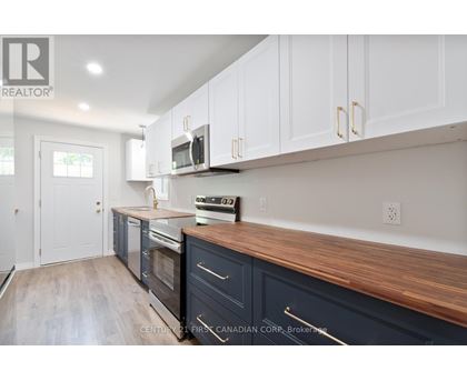 A kitchen with white cabinets and a wooden countertop.