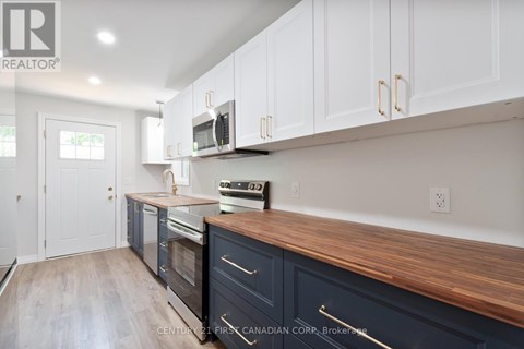 A kitchen with white cabinets and a wooden countertop.