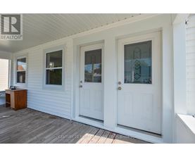 A white house with a porch and two doors.