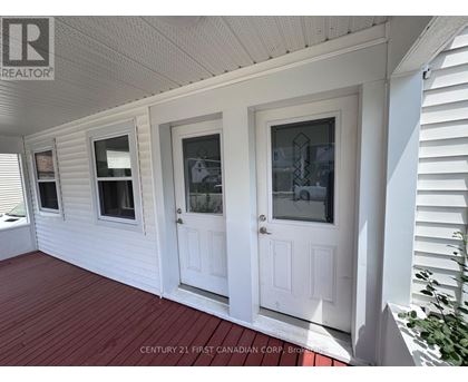 A white house with a porch and two doors.