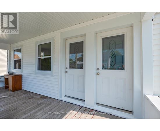 A white house with a porch and two doors.