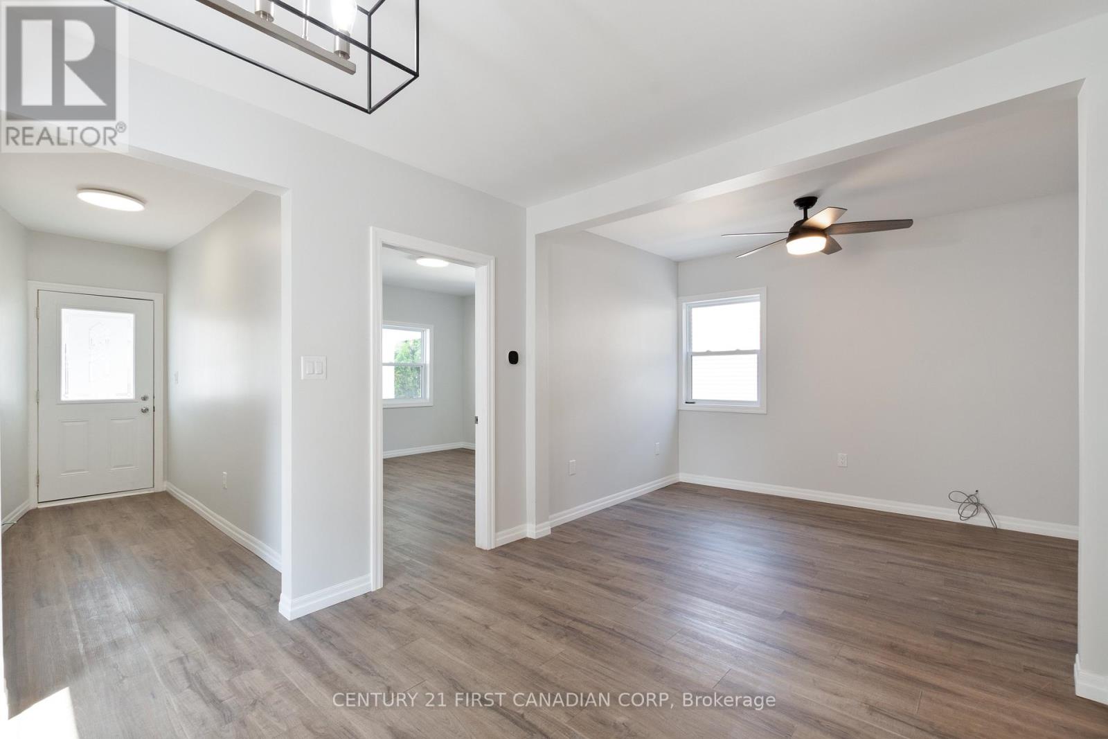 A spacious room with wooden floors and white walls.