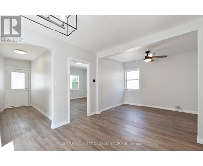 A spacious room with wooden floors and white walls.
