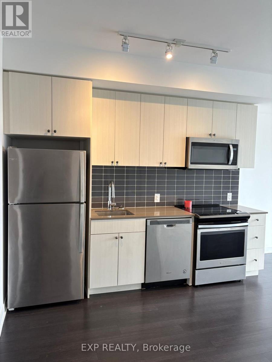 A kitchen with white cabinets and a stainless steel refrigerator.