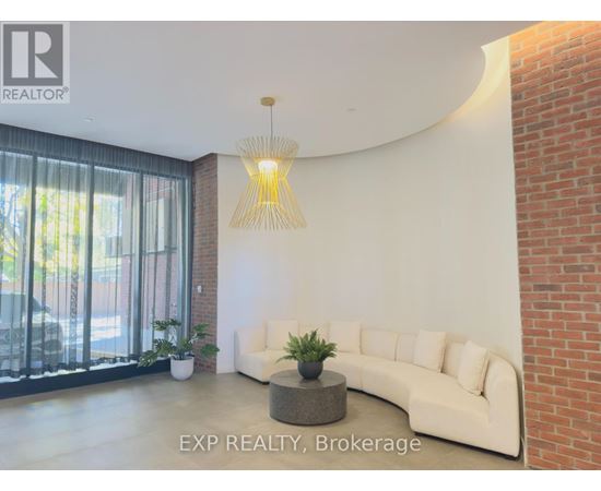 A living room with a white couch and a hanging light fixture.