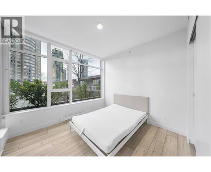 A bedroom with a large bed and a view of the city.