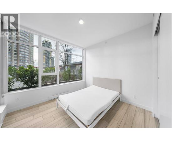 A bedroom with a large bed and a view of the city.