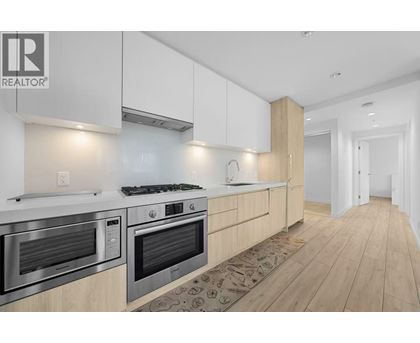 A modern kitchen with wooden cabinets and stainless steel appliances.
