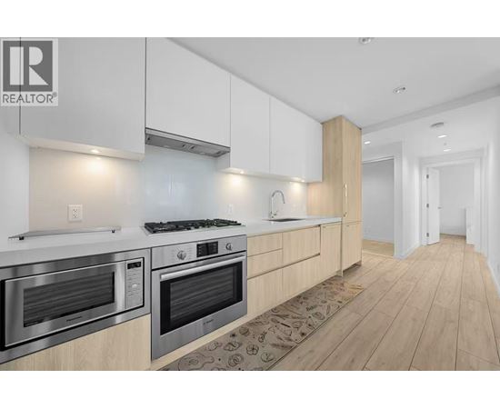 A modern kitchen with wooden cabinets and stainless steel appliances.