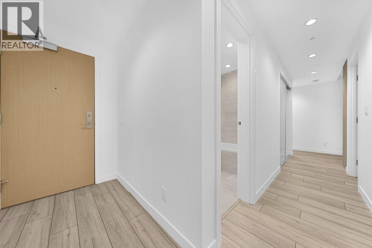 A hallway with a wooden floor and white walls.