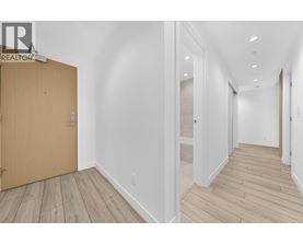A hallway with a wooden floor and white walls.
